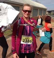 Runner holding a finisher medal after completing the Little Rock Marathon.
