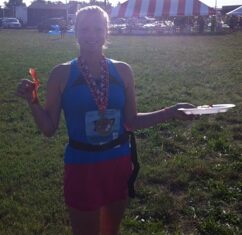 Runner wearing a finisher medal after completing the Heart and Soul Half Marathon.