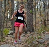 Runner navigating a wooded trail during the Arkansas Trail Run Series Race the Base event.